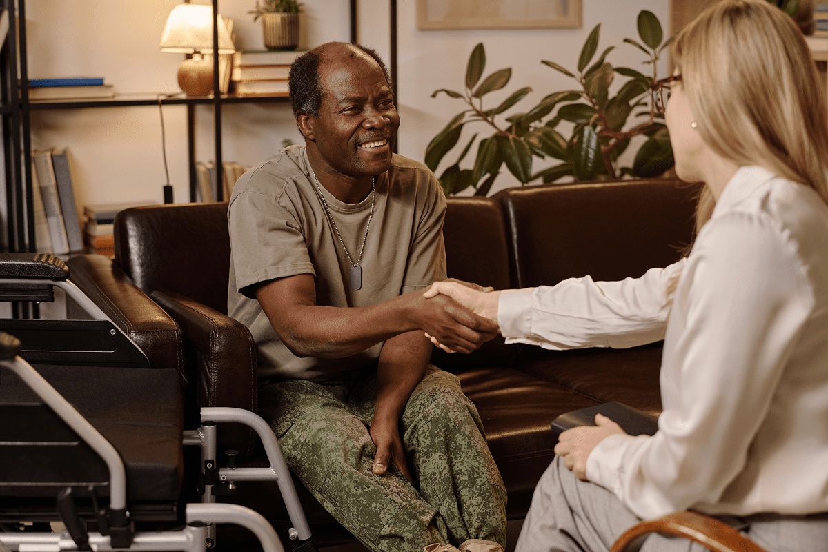 Two people shaking hands in living room.