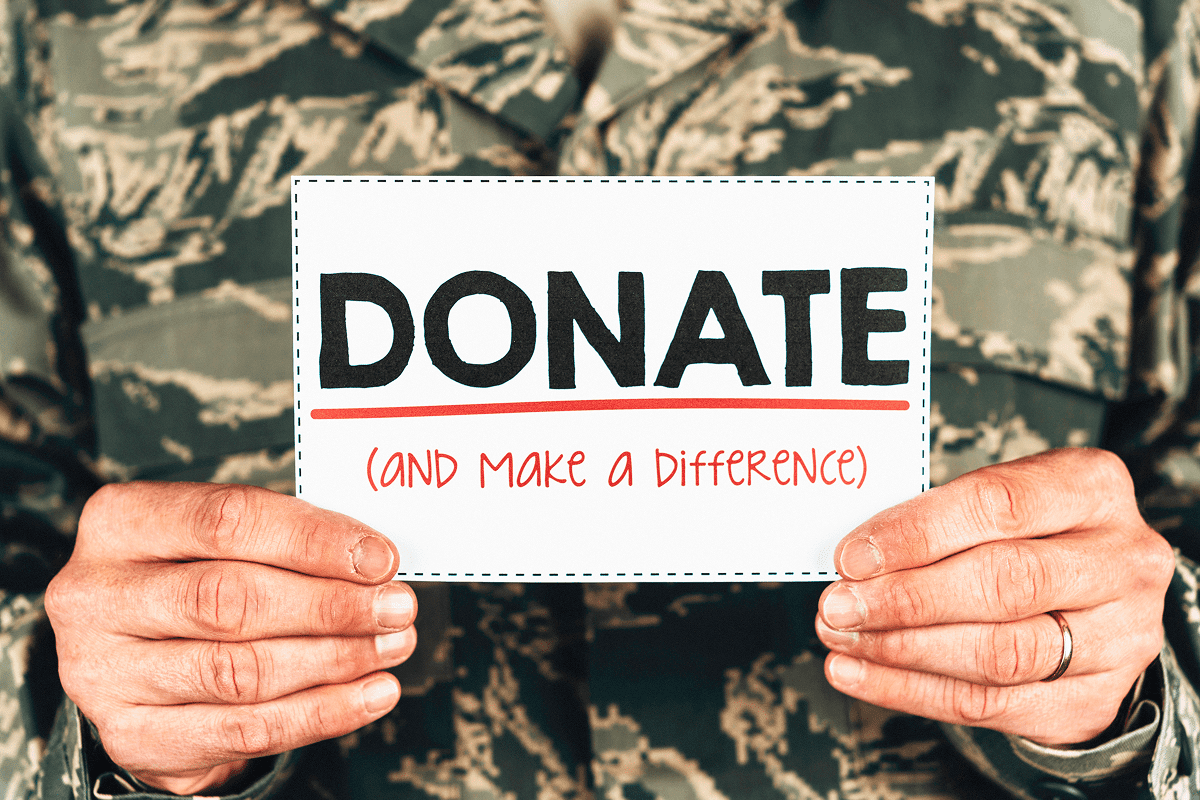 Person holding "Donate and Make a Difference" sign.